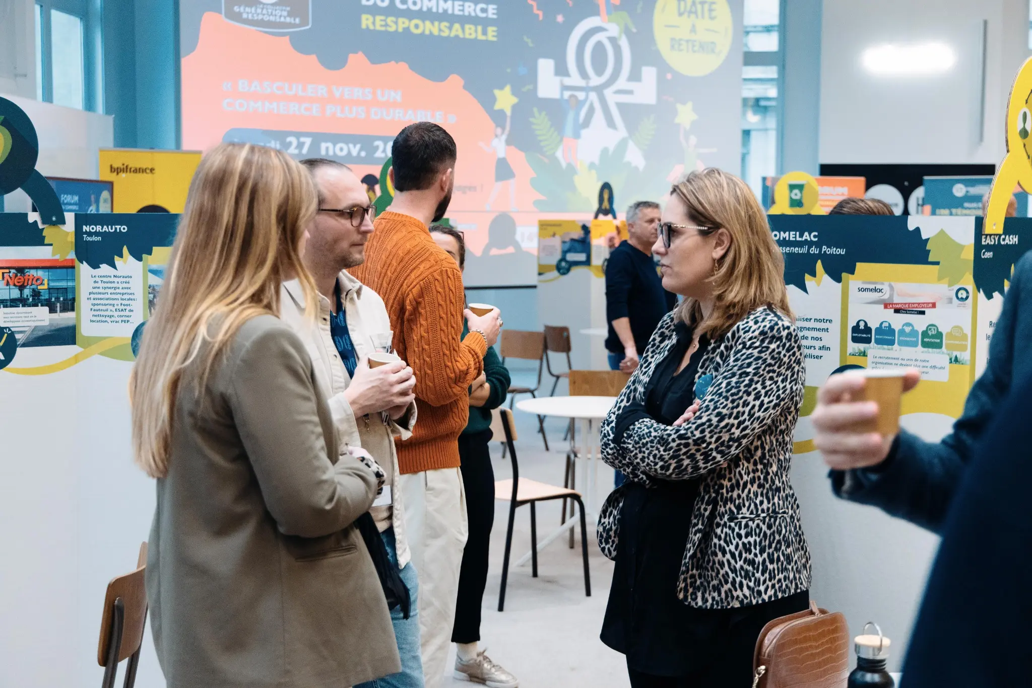 Participants échangeant devant les initiatives des enseignes
